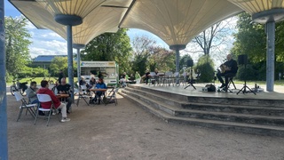 Menschen sitzen vorm Kaffeehäusle im Horbachpark